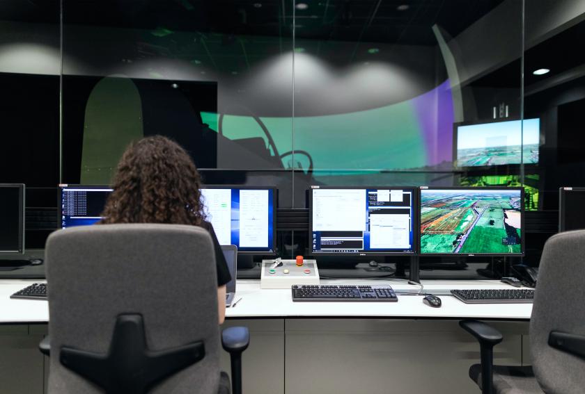 Woman sitting at a desk with multiple screens on